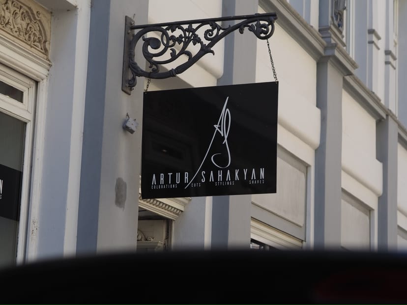 Ausleger-Schild mit dem Artur-Sahakyan-Logo an der Hausfassade