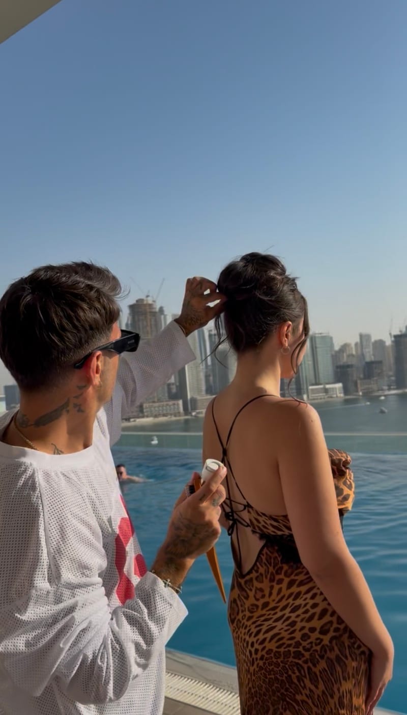 Artur Sahakyan steckt einer Kundin die Haare hoch, im Hintergrund eine Hochhaus-Skyline